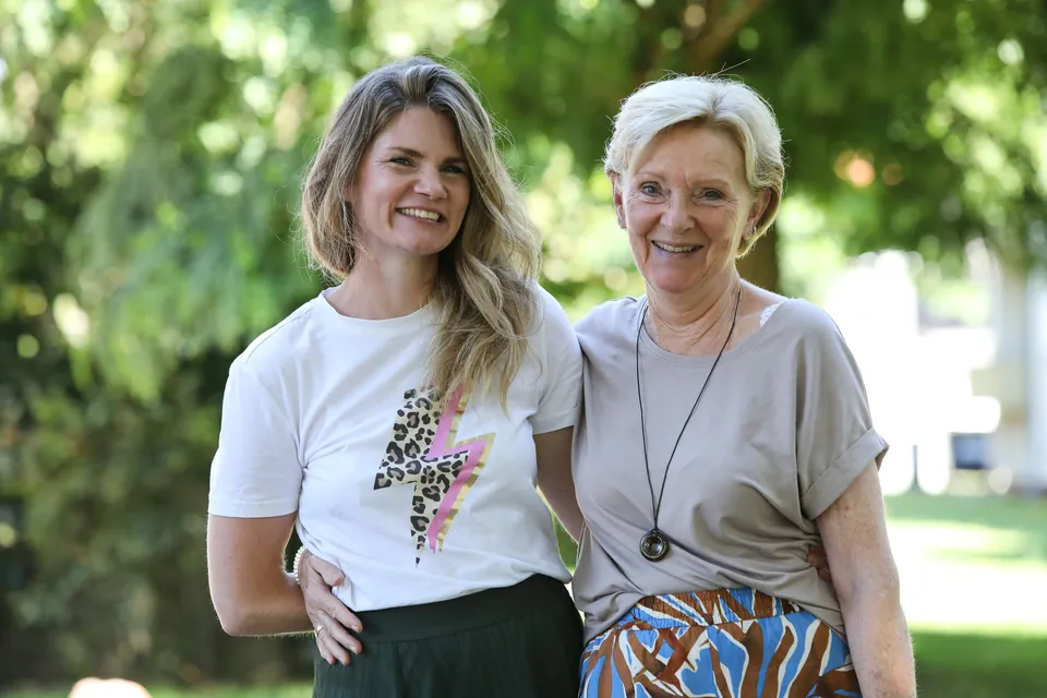 Lena Felten und ihre Mutter Gudrun Klages stehen lachend Arm in Arm im Garten